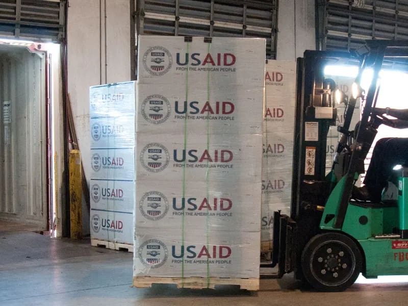 Forklift loading palletised goods in a logistics warehouse